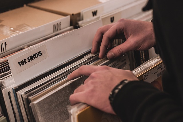 Man paging through old vinyls known as The Smiths