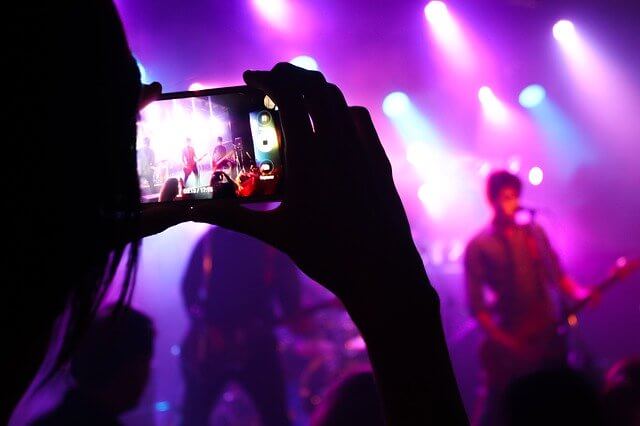 Person recording a band on their phone at a concert