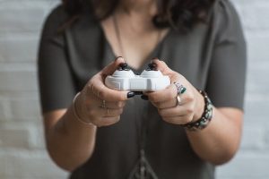 woman holding a white wireless video game controller